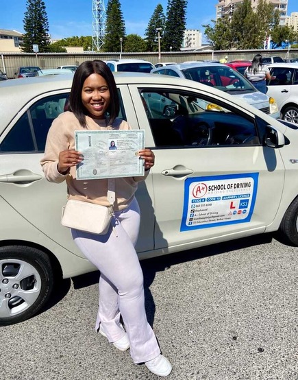 A+ learner with a driving licence beside a training car